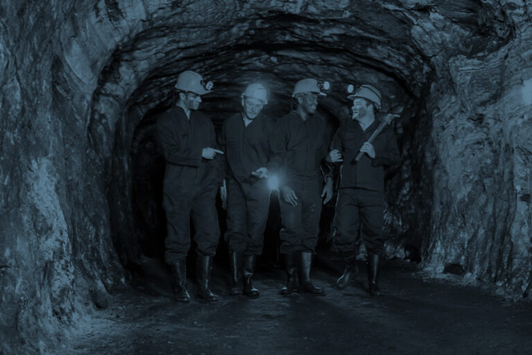 Monochrome photograph of a group of miners underground