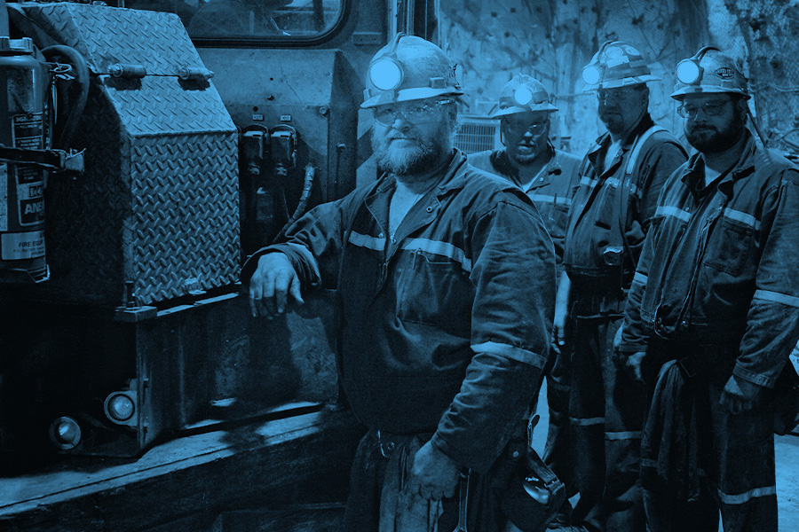 Monochrome photograph of a group of miners underground