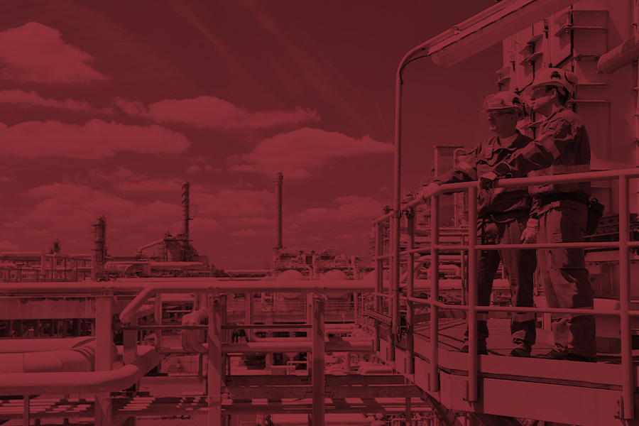 Monochrome photo of two workers overlooking a power plant