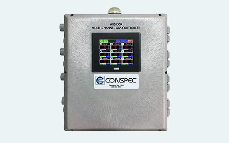 Photograph of AUSID09 fixed natural gas leak detection controller with optional RD custodian panel on white background, showing touchscreen interface, relay outputs, and NYCSCA-compliant design.
