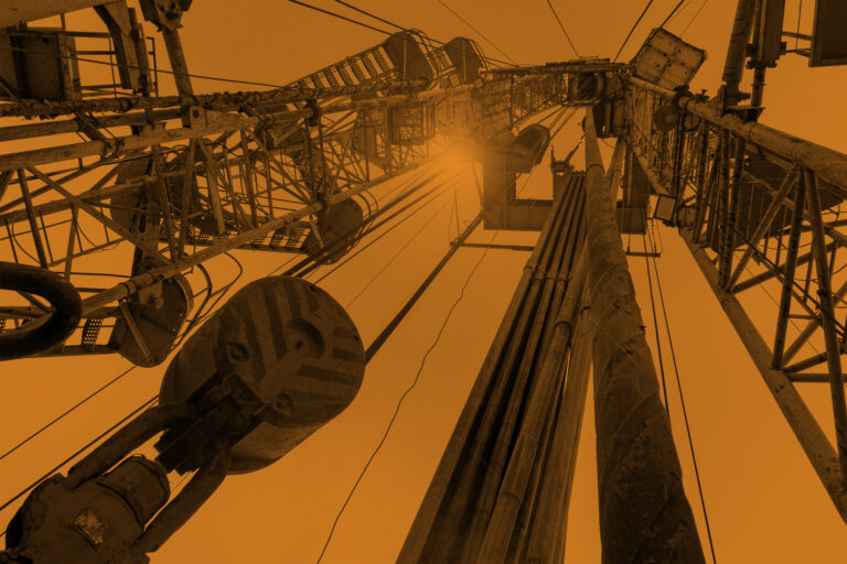 Oil and Gas Drilling Rig onshore dessert with dramatic cloudscape. Oil drilling rig operation on the oil platform in oil and gas industry.