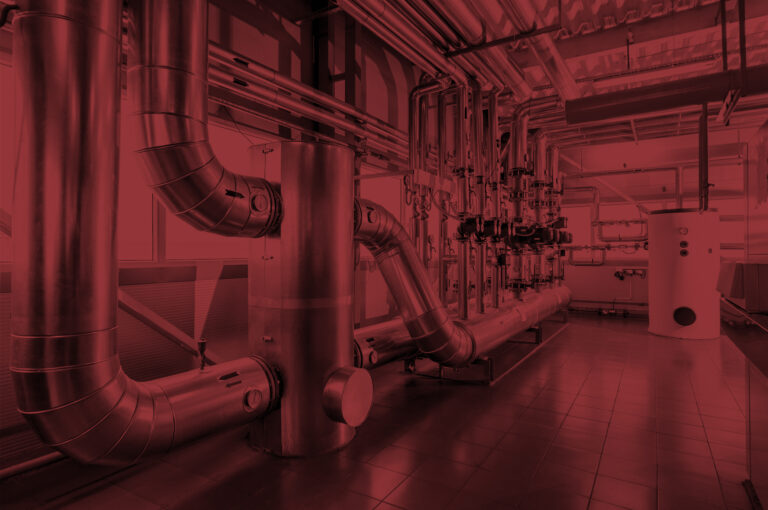 Vents and pipes along the wall of an industrial work environment.