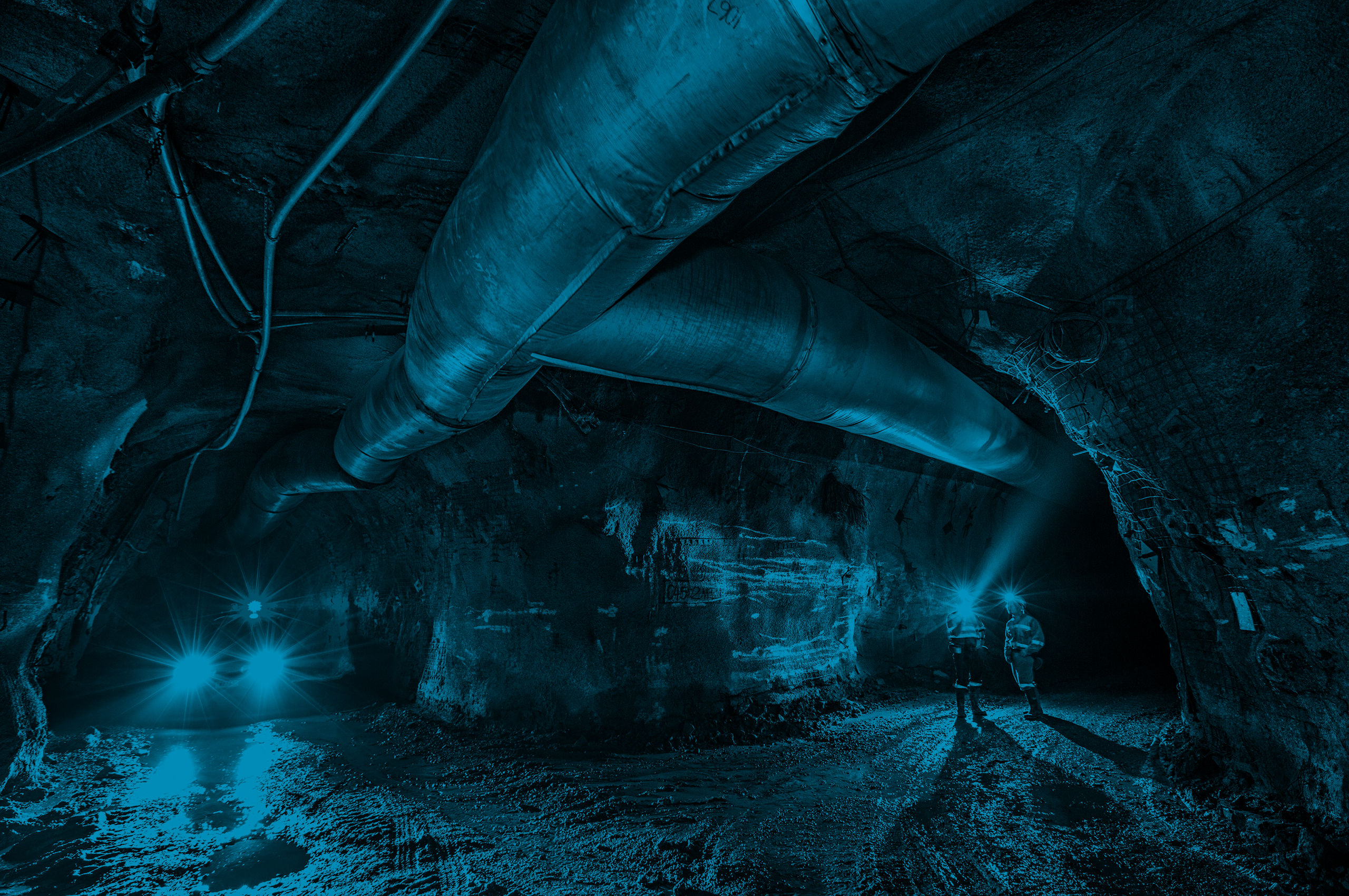 Miners and heavy machinery move underground.