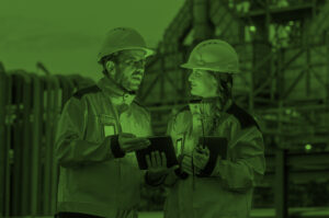 Personnel wearing safety equipment stand in front of manufacturing facility.